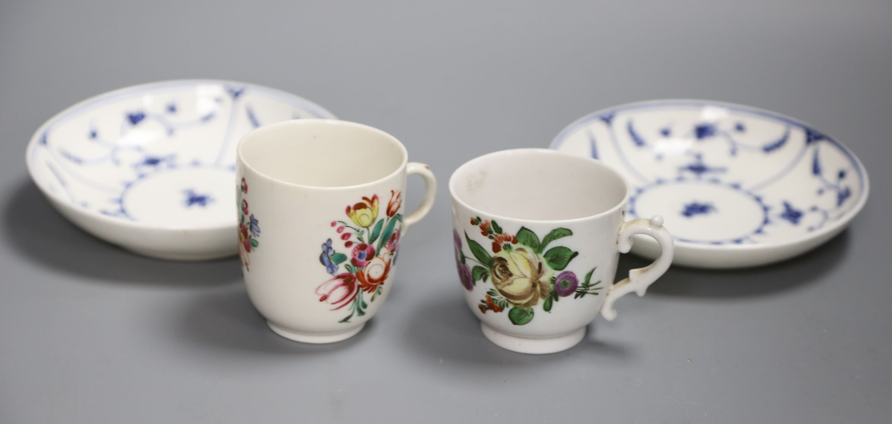 An 18th century Doccia cup with early scroll handle painted with flowers, another Doccia cup similarly decorated with a kick handle